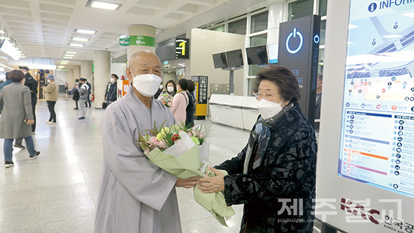 우경 스님이 김문자 제23교구 신도회장으로부터 꽃다발을 전해 받고 있다.